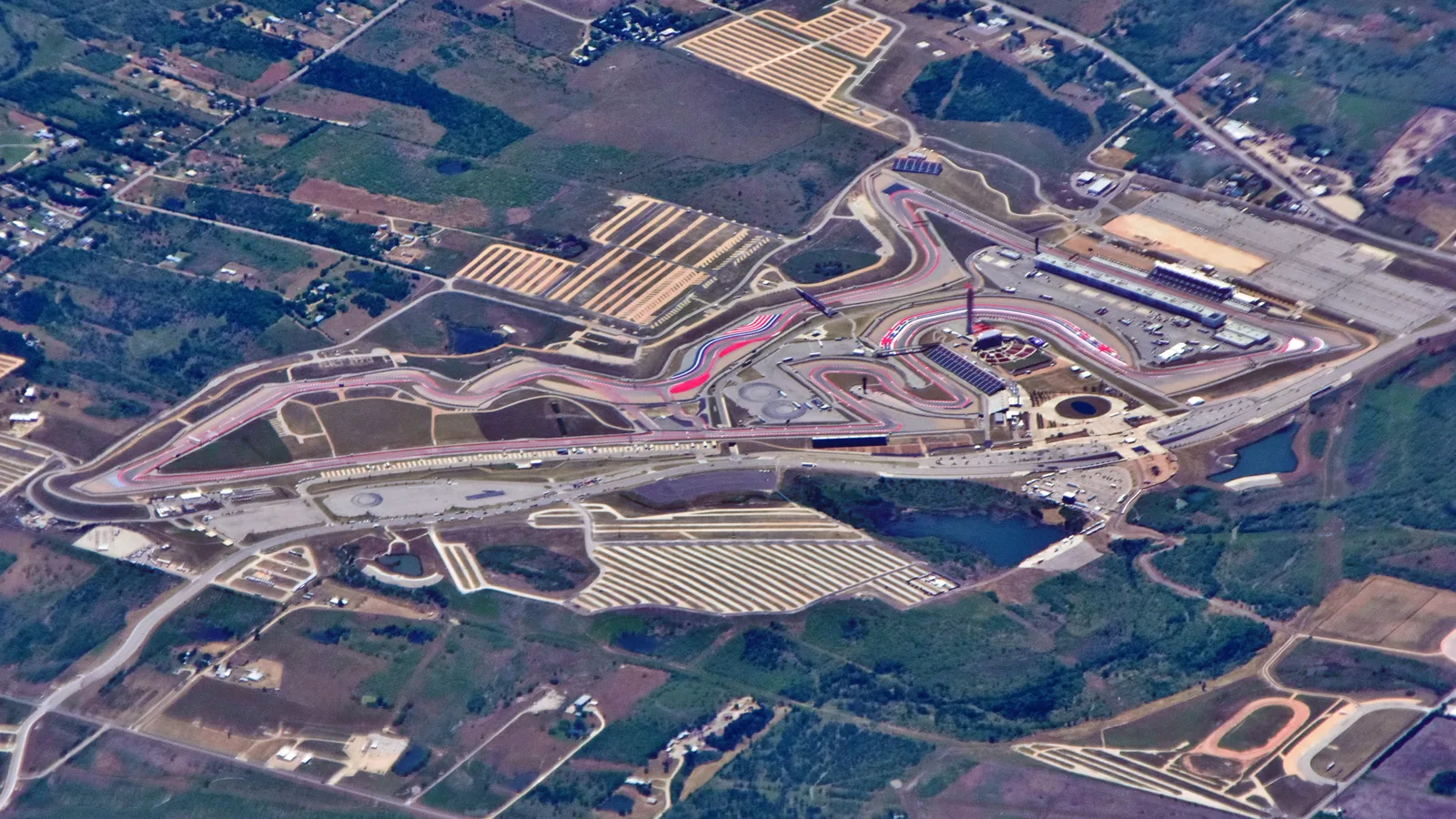 Flygbild över Circuit of the Americas med banans kurvor, läktare och omgivande fält.