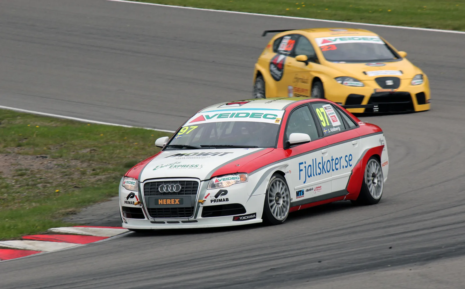 Joakim Ahlberg i en vit och röd Audi A4 med startnummer 97 på Ring Knutstorp, med en gul SEAT bakom.